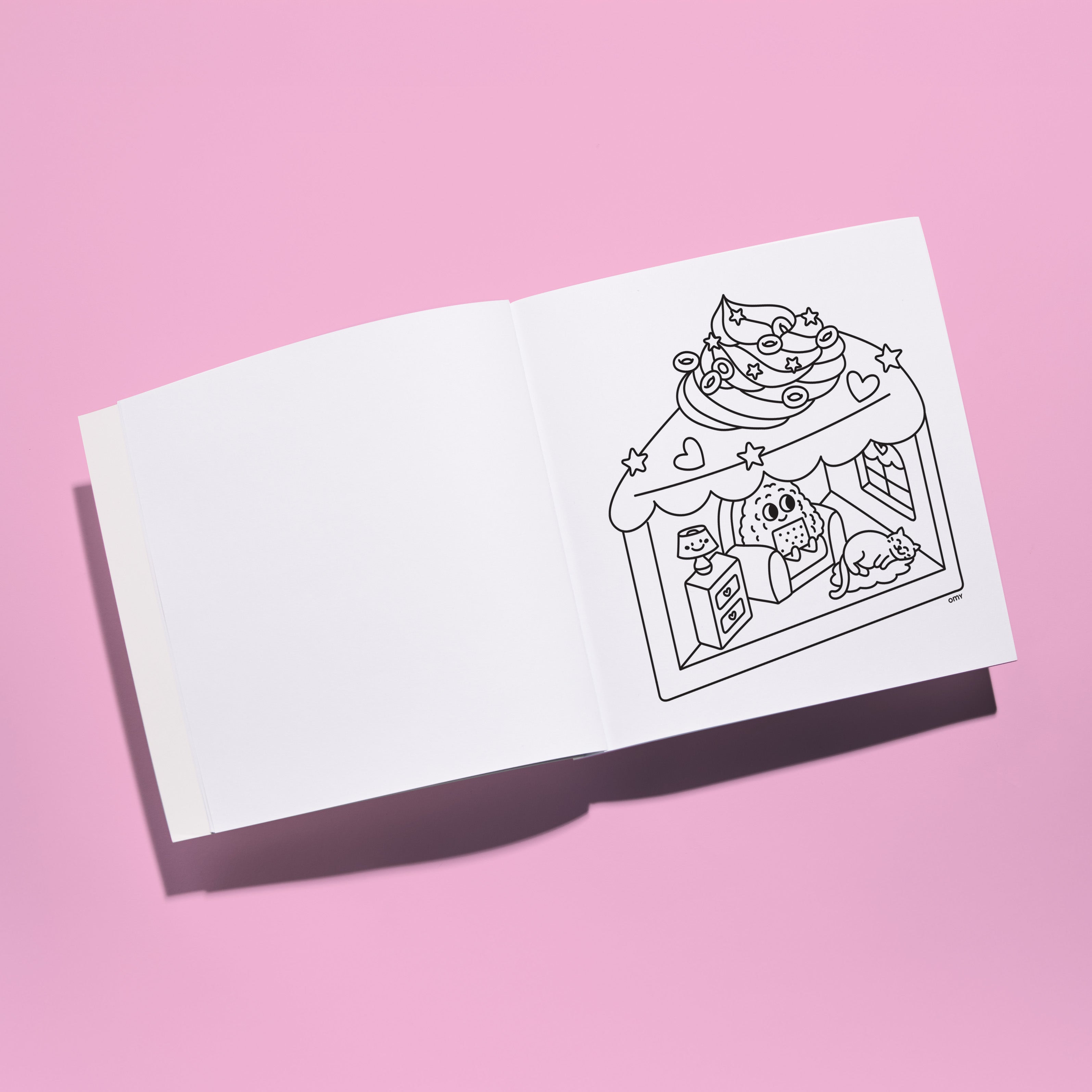 Interior view of Cozy Art Kawaii coloring book featuring a blank left page and a cute dessert shop illustration on the right page, displayed on a pastel pink background for coloring.