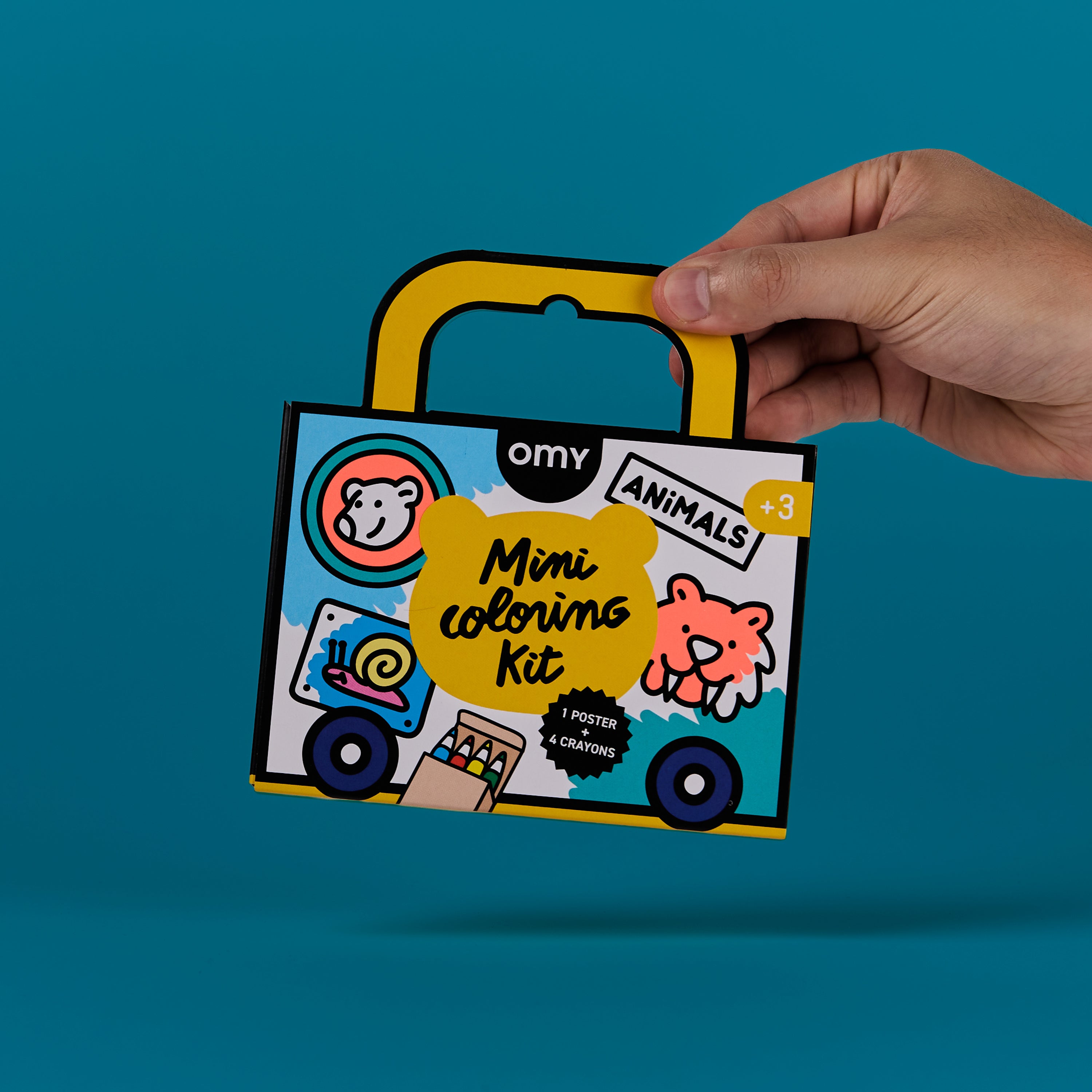 Front view of OMY Mini Coloring Kit Animals edition held by hand, featuring animal illustrations and mini crayons for kids; portable coloring kit.