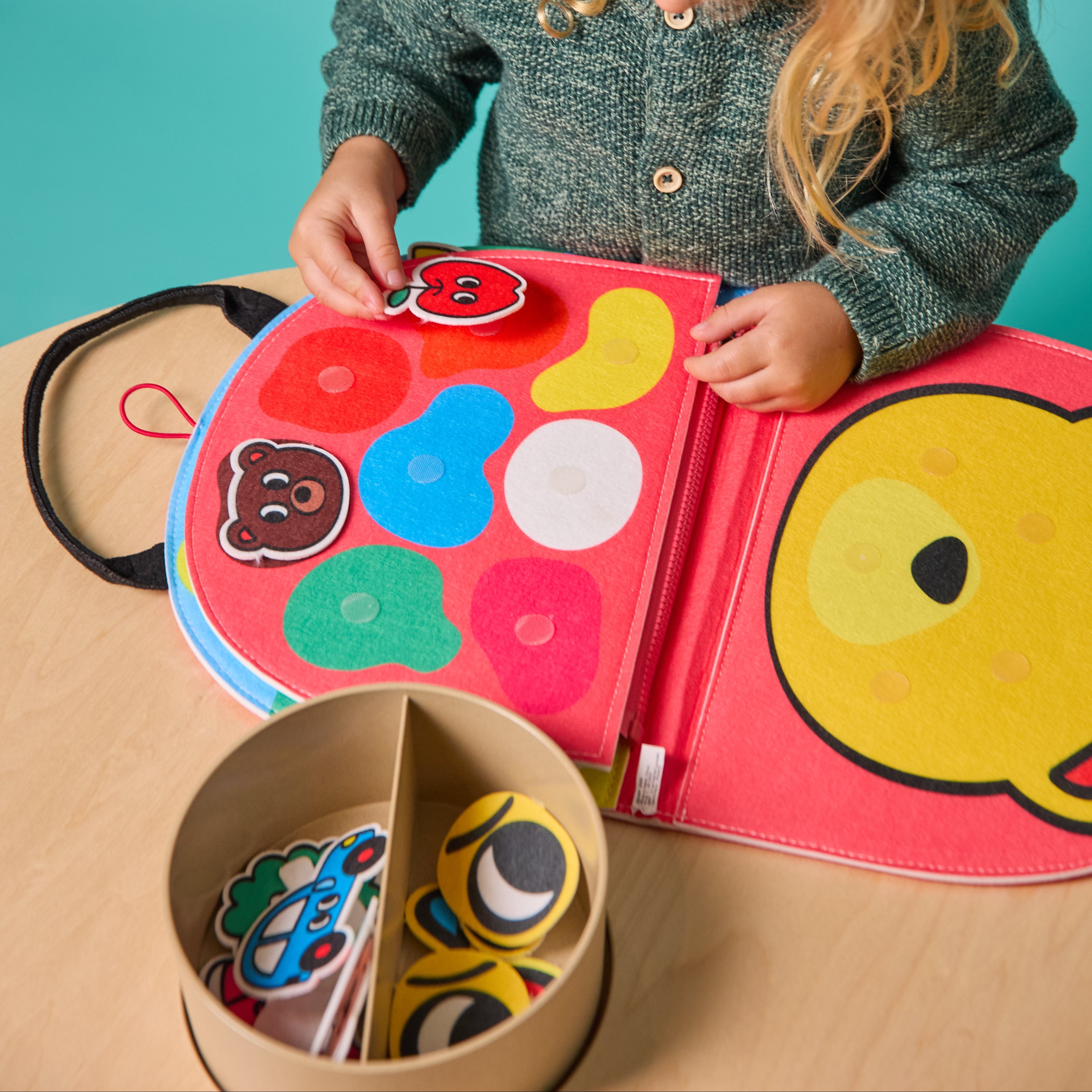Toddler playing with Montessori felt shapes β sensory activity board teaching colors, shapes, and fine motor skills.
