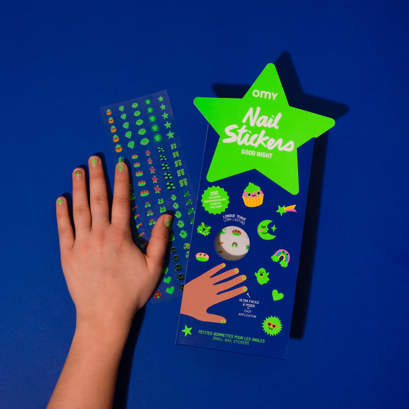 Nail sticker Glow Party packaging with a hand showing off green nail designs on a blue background