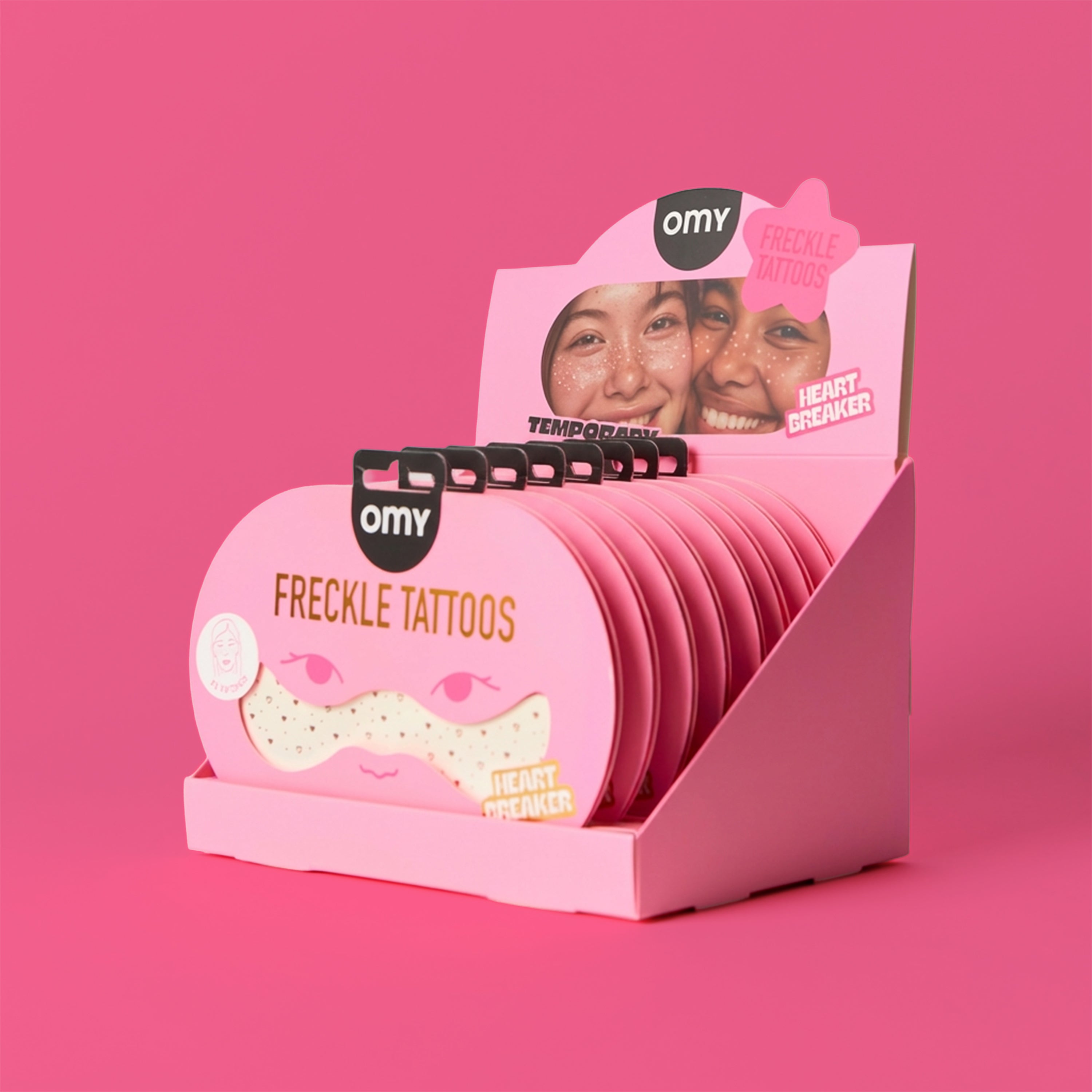 Display of OMY freckle tattoos on a pink background