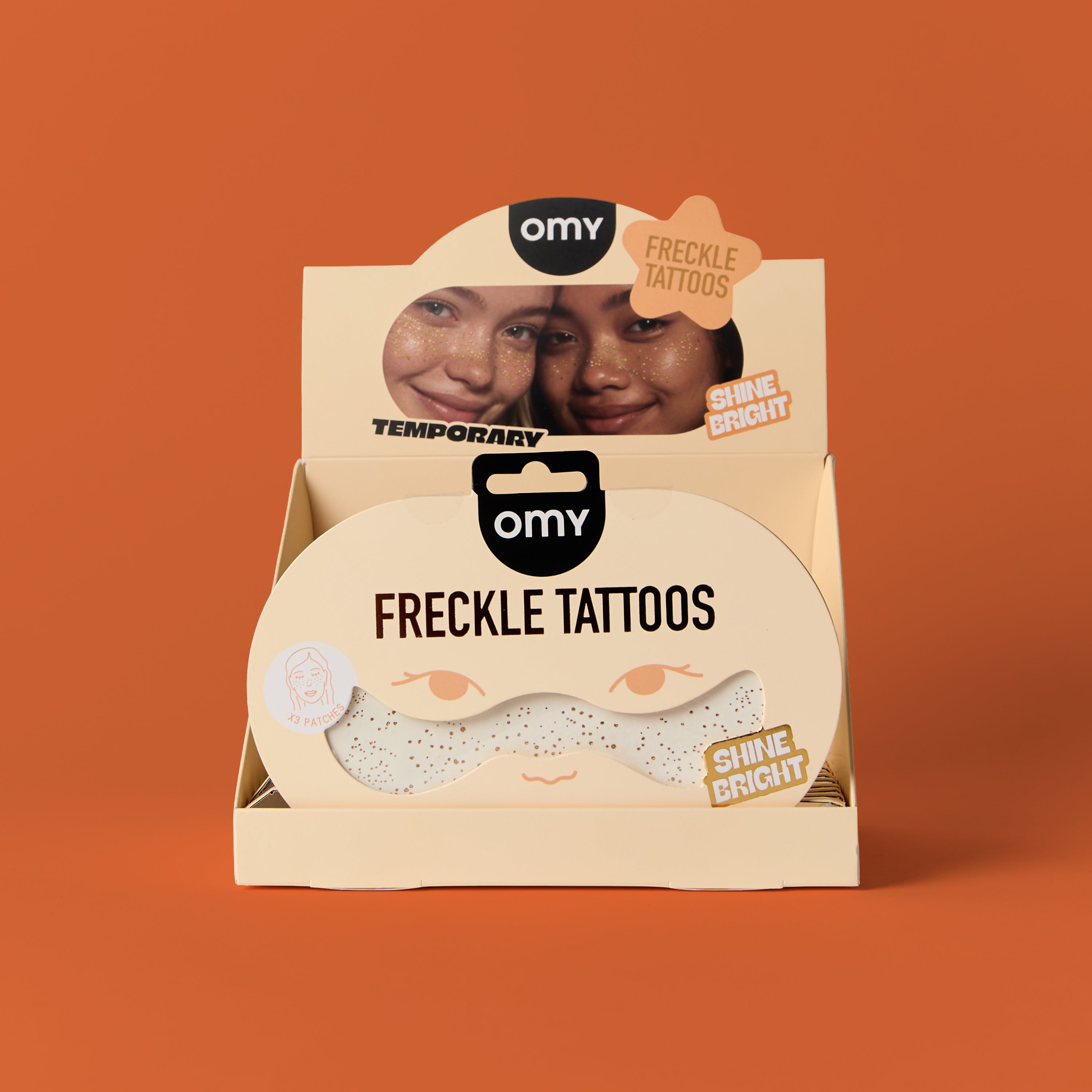 Packaging of OMY freckle tattoos on an orange background