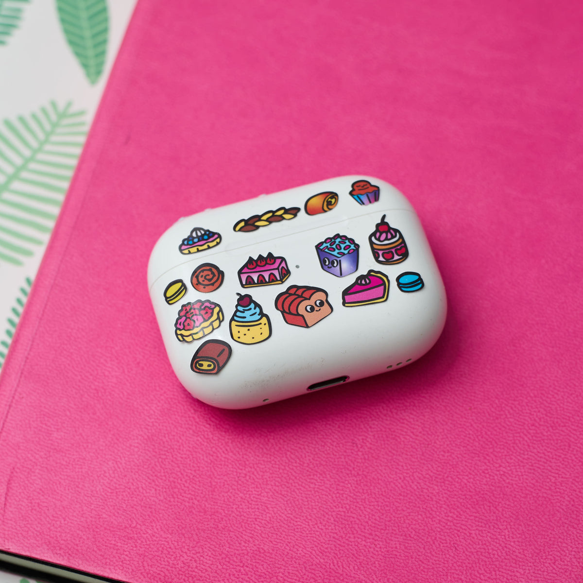 White case with colorful fabulous stickers on a pink surface