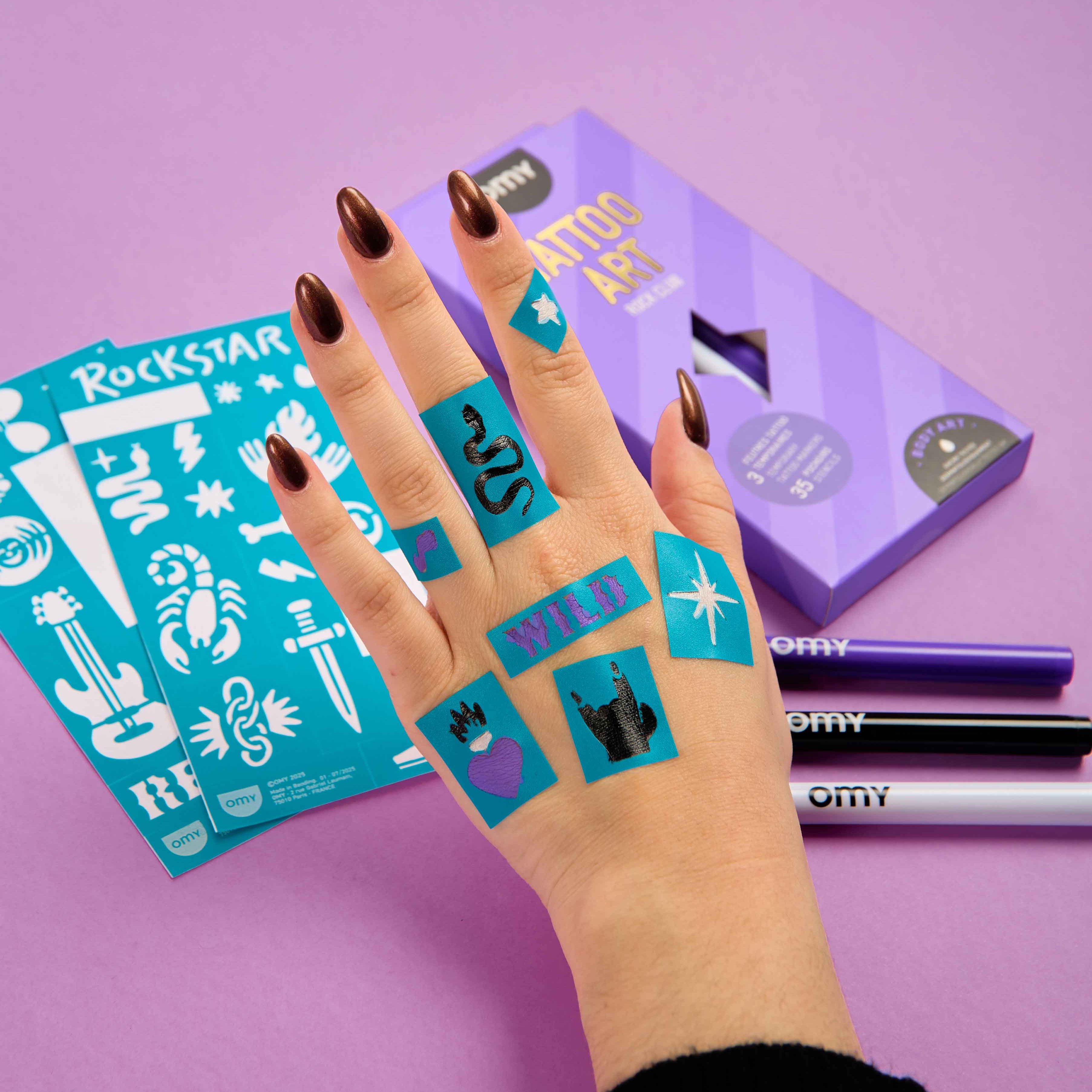 Rock-style temporary tattoos created with OMY Tattoo Art markers and stencils on hand