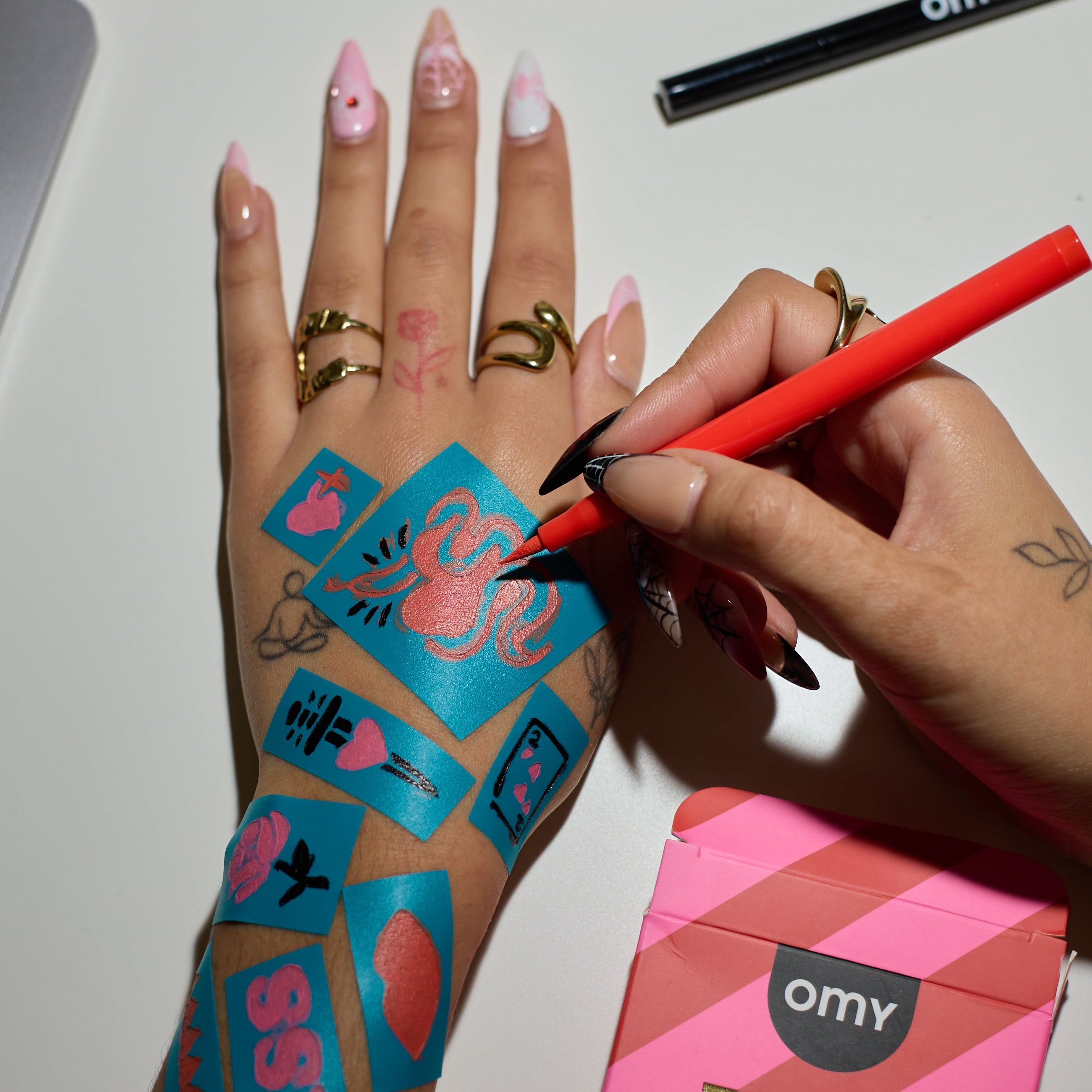 Applying a temporary tattoo using OMY Tattoo Art marker and stencil on hand