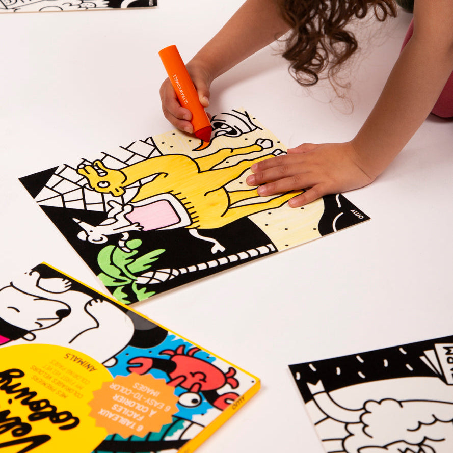 Child coloring a Velvet Animals activity sheet with an OMY marker