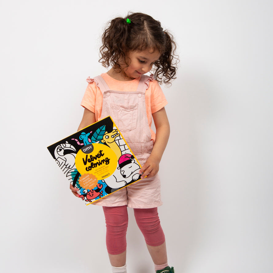 Child holding the Velvet Animals coloring set by OMY