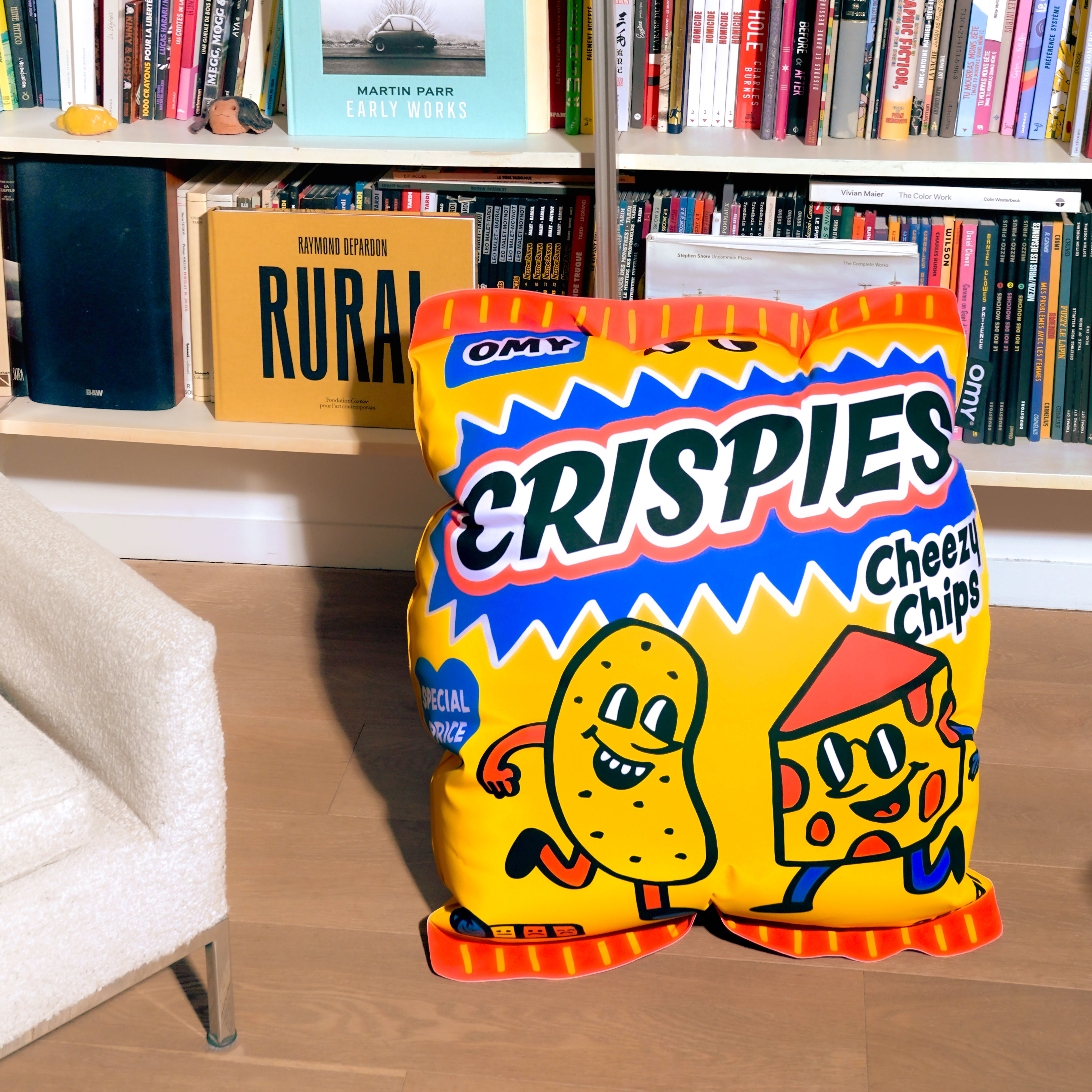 Crispies Cheesy Chips OMY Air Pillow bag in a room with books and a couch