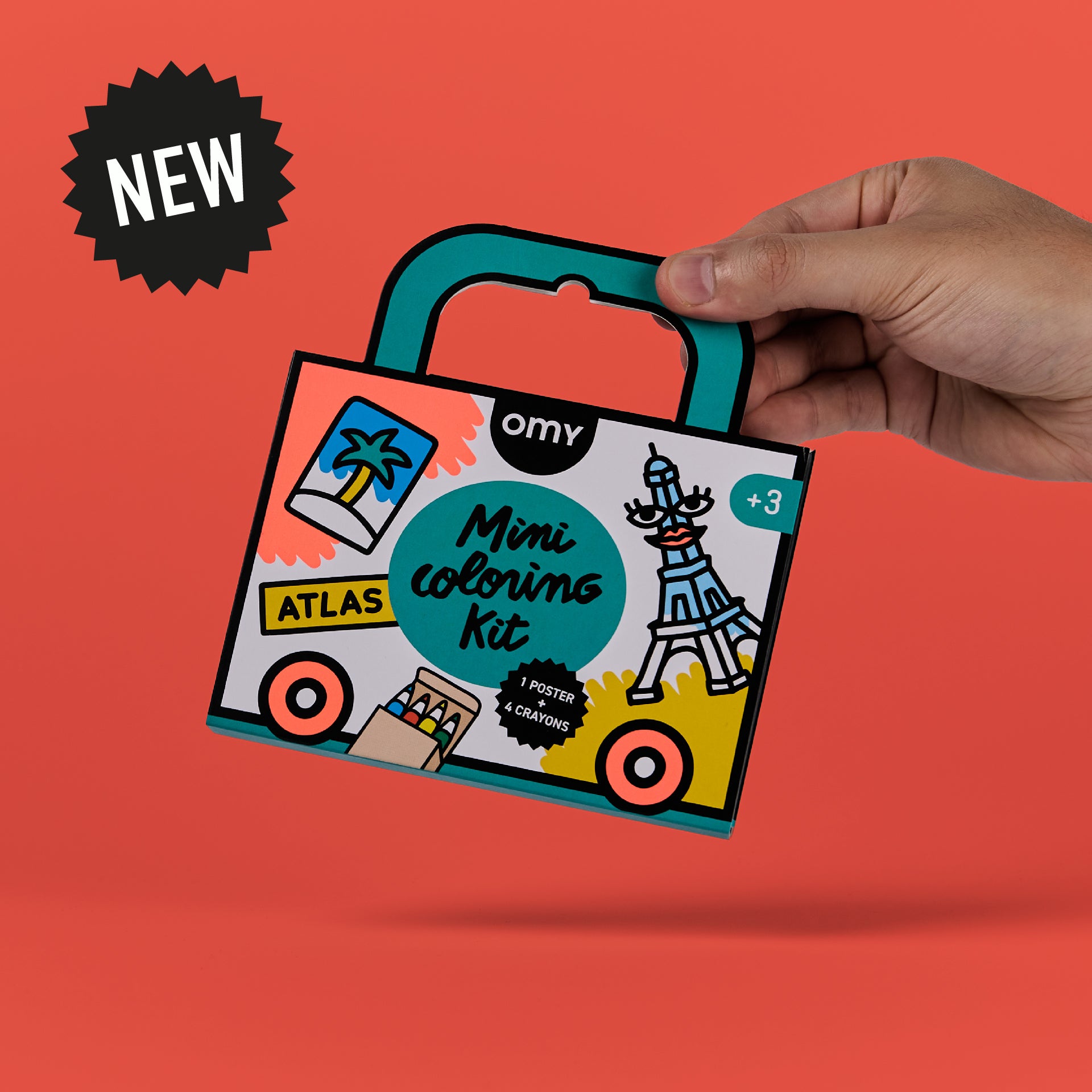 Hand holding OMY Mini Coloring Kit – Atlas edition suitcase-style coloring kit featuring travel-themed illustrations like the Eiffel Tower and palm tree on red background with 'NEW' badge; portable coloring kit for kids ages 3 and up that includes a poster and crayons.