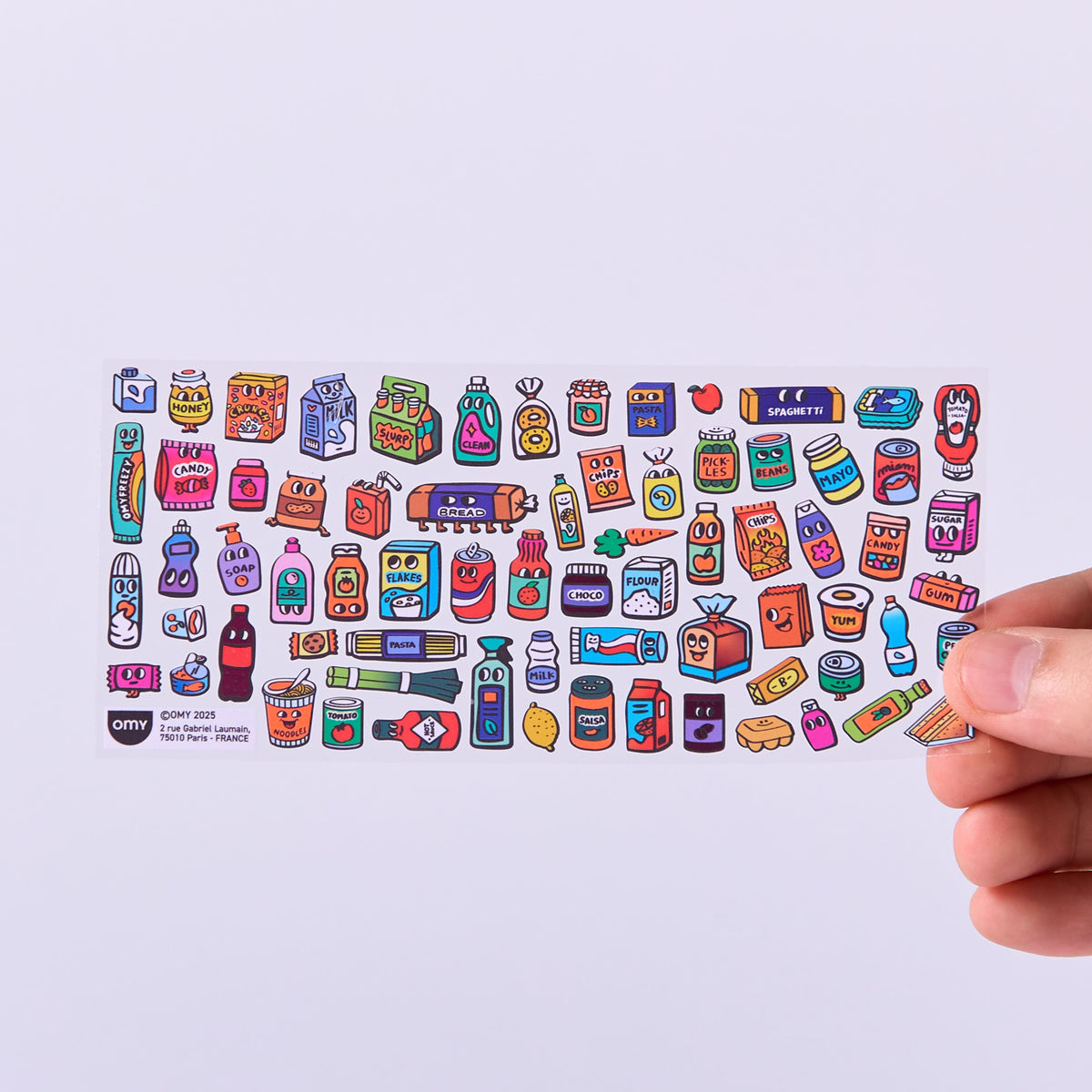 Collection of colorful stickers OMY on a white background with a hand holding them.