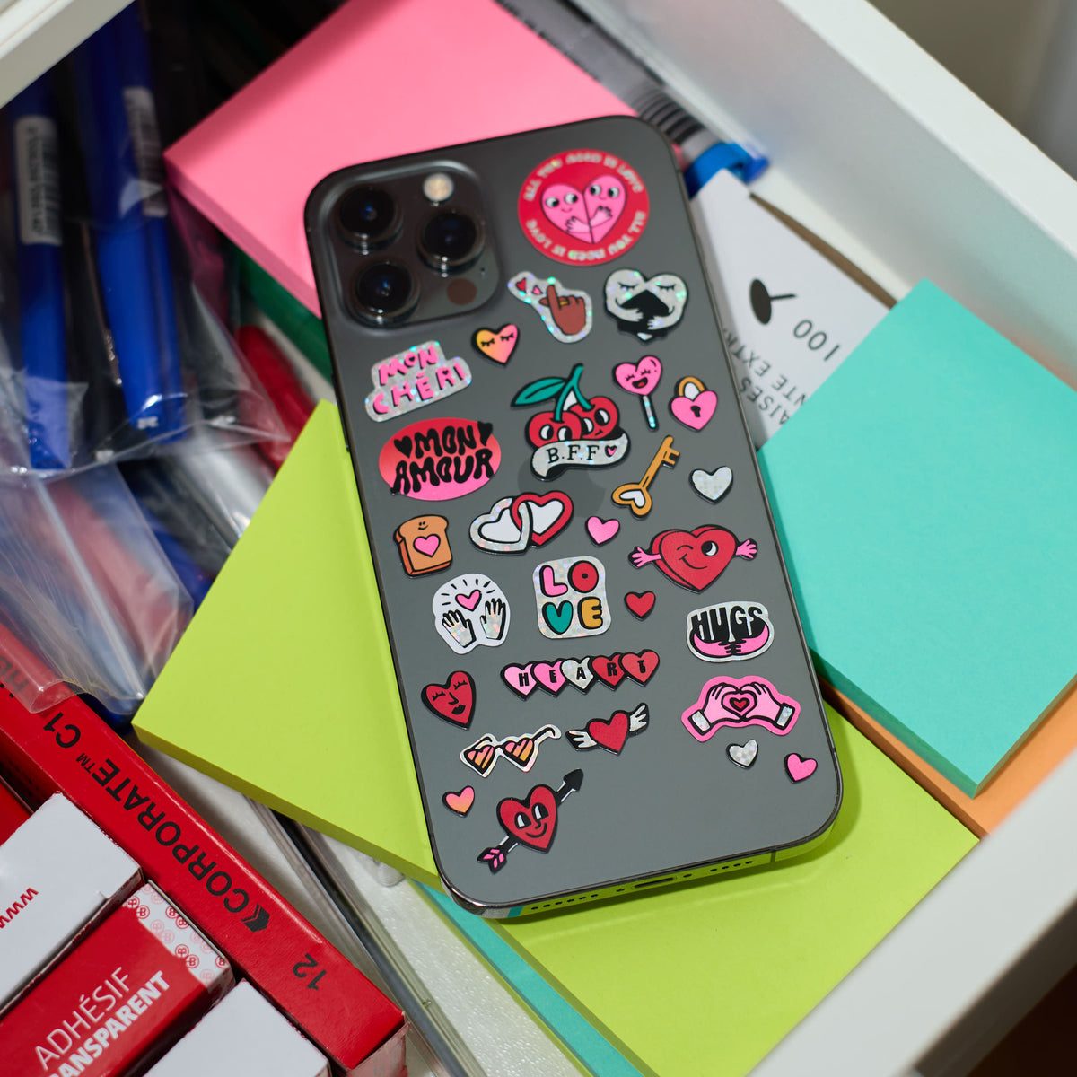 Phone case with colorful fabulous stickers on a desk with stationery items
