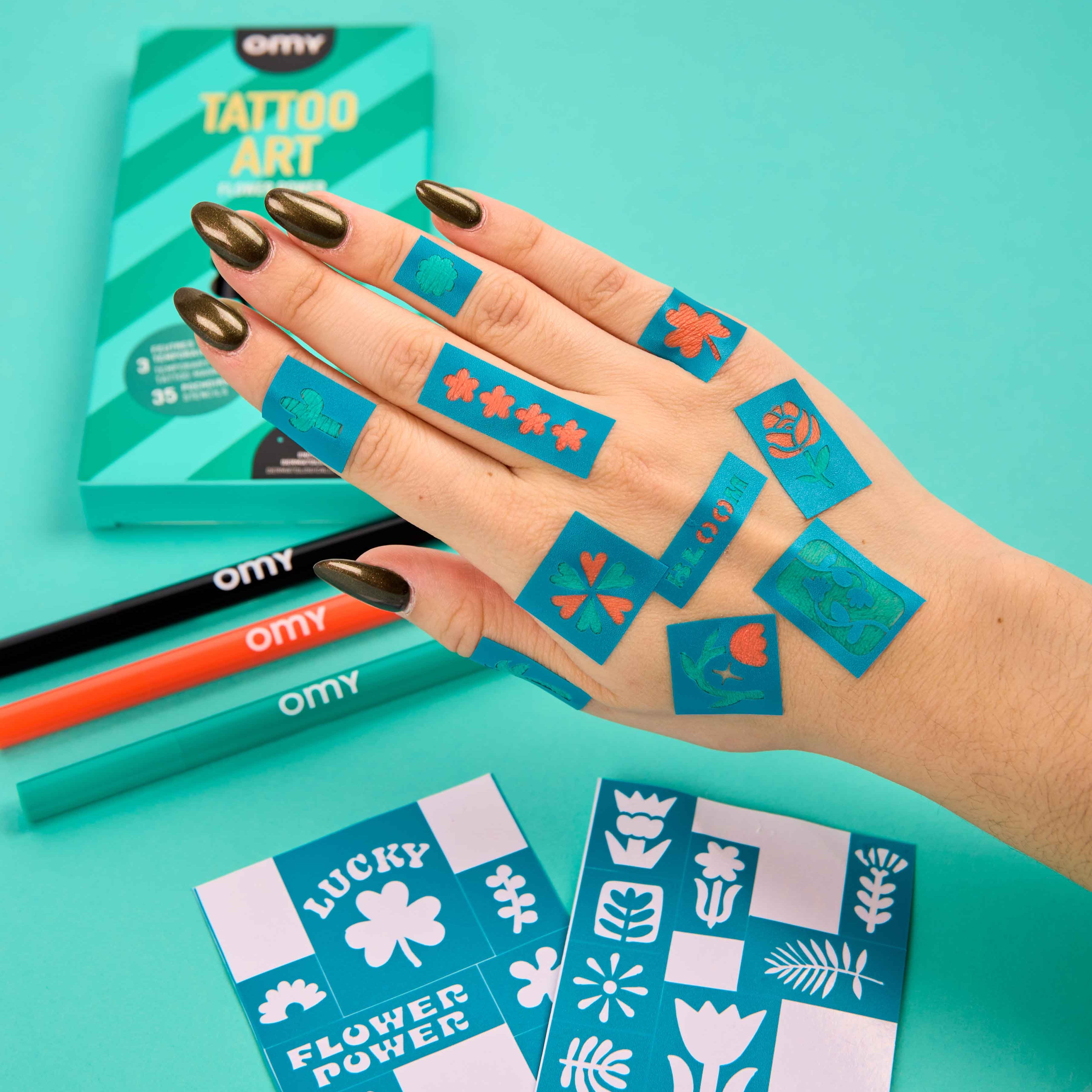 Temporary flower tattoos created with OMY Tattoo Art markers and stencils on hand