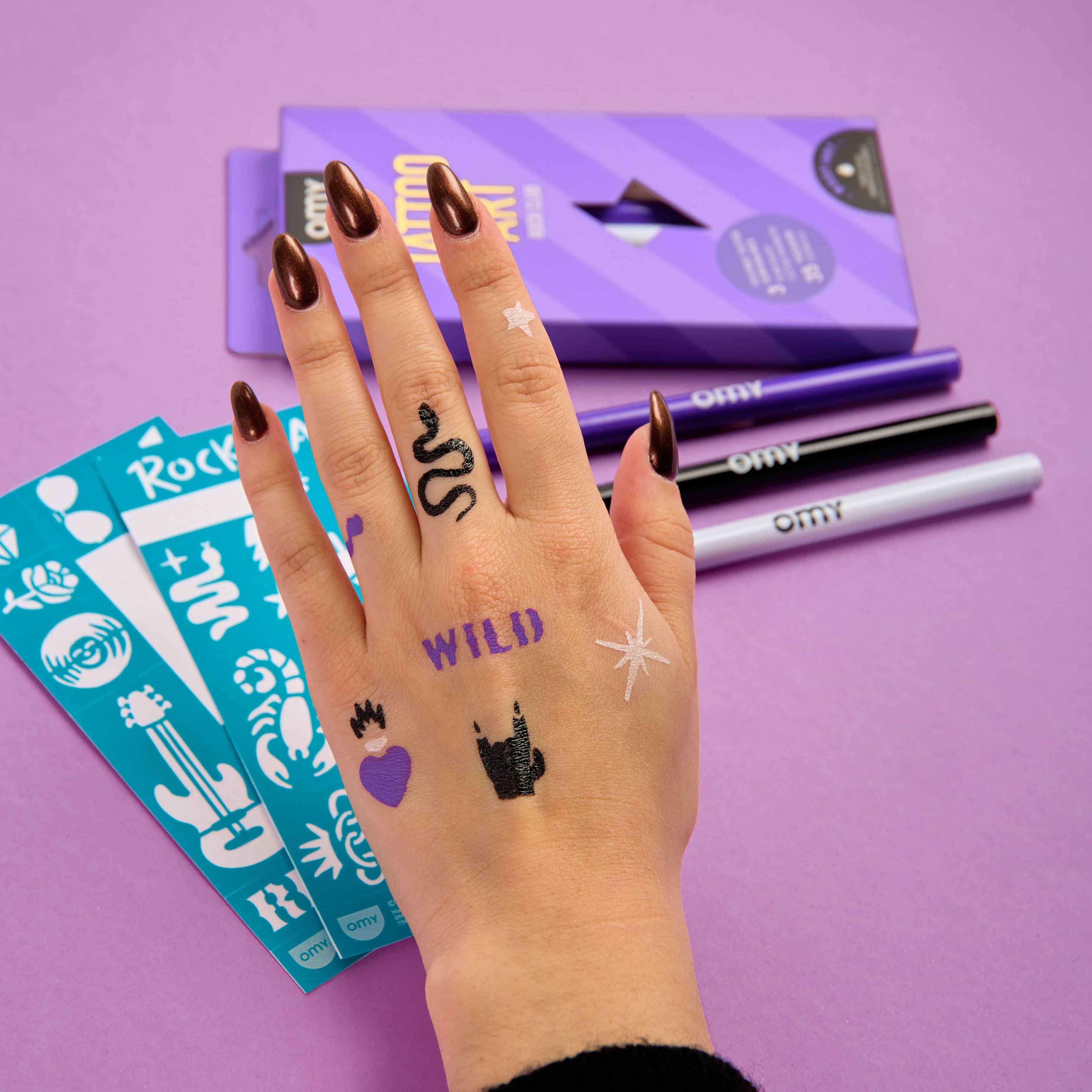 Temporary rock-inspired tattoos drawn on hand with OMY Tattoo Art skin markers