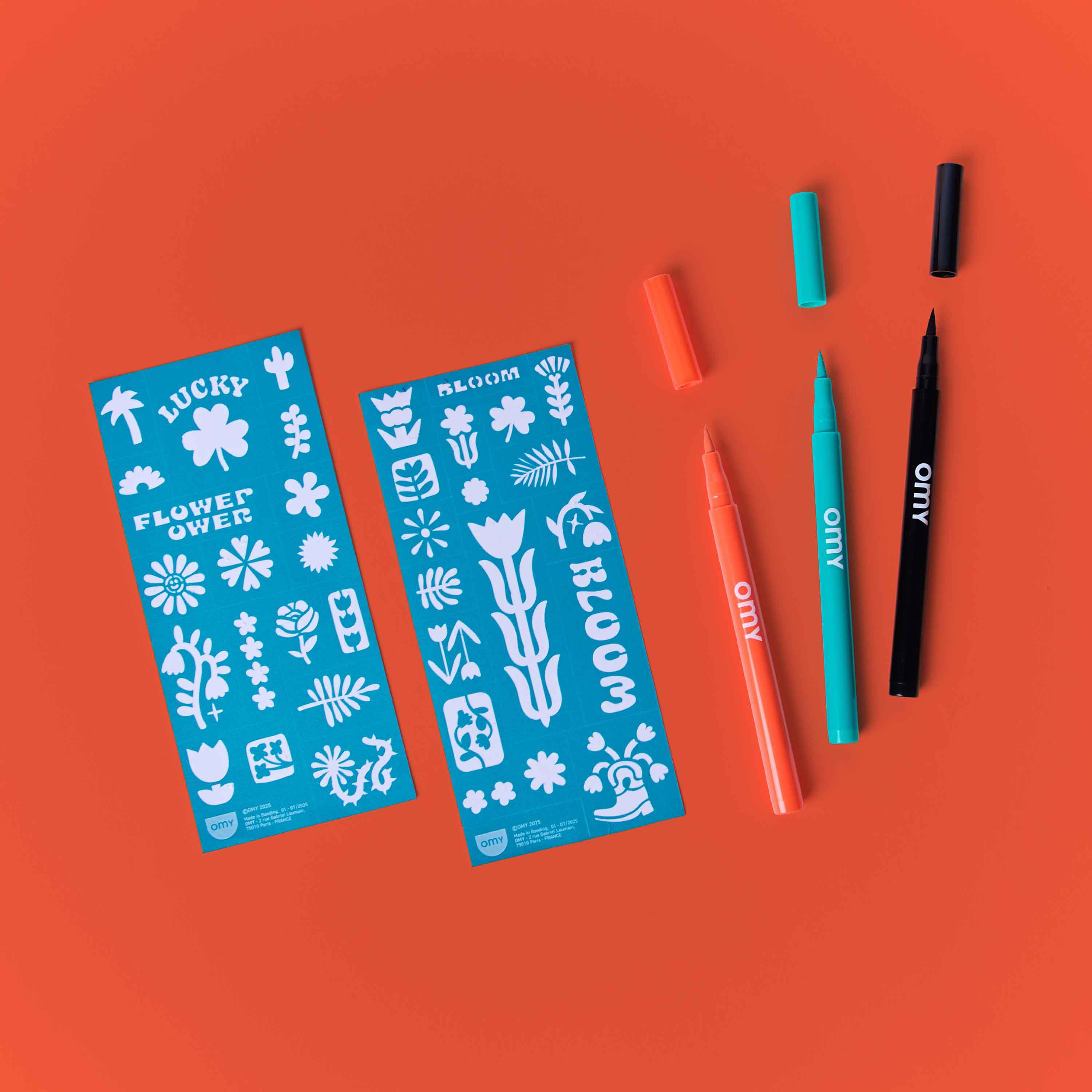 OMY Tattoo Art Flower Power kit with temporary tattoo markers and floral stencils on orange background